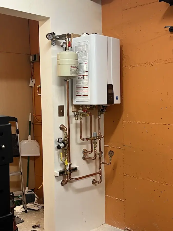 Plumbing technician inspecting water heater connections in Tooele
